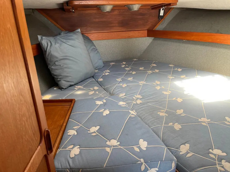 Slide: The Image of 1986 Tiara Yachts 3100 Open cabin interior with floral-patterned bedding and wooden accents. - 6