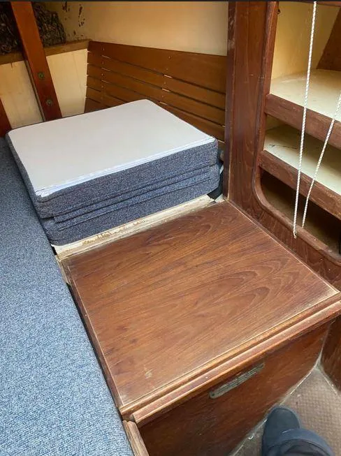 Slide: The Image of Interior of 1990 Bristol Channel Cutter 28 with wooden cabinetry and stacked cushions. - 13