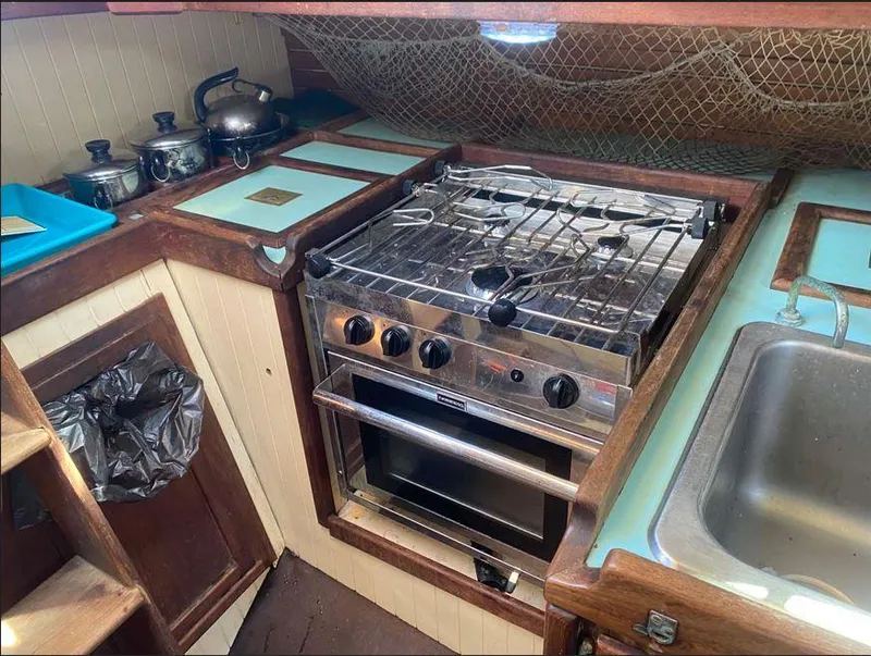 Slide: The Image of 1990 Bristol Channel Cutter 28 kitchen with stove, sink, and cookware in a compact layout. - 17