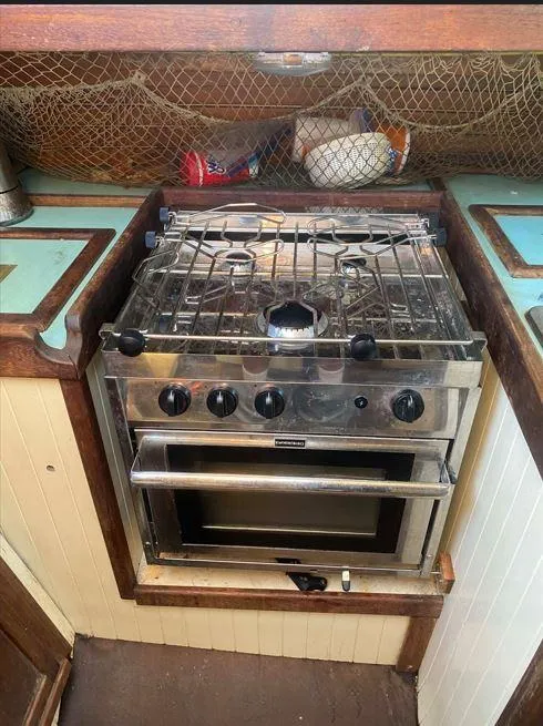 Slide: The Image of 1990 Bristol Channel Cutter 28 kitchen with stove and nautical decor. - 18