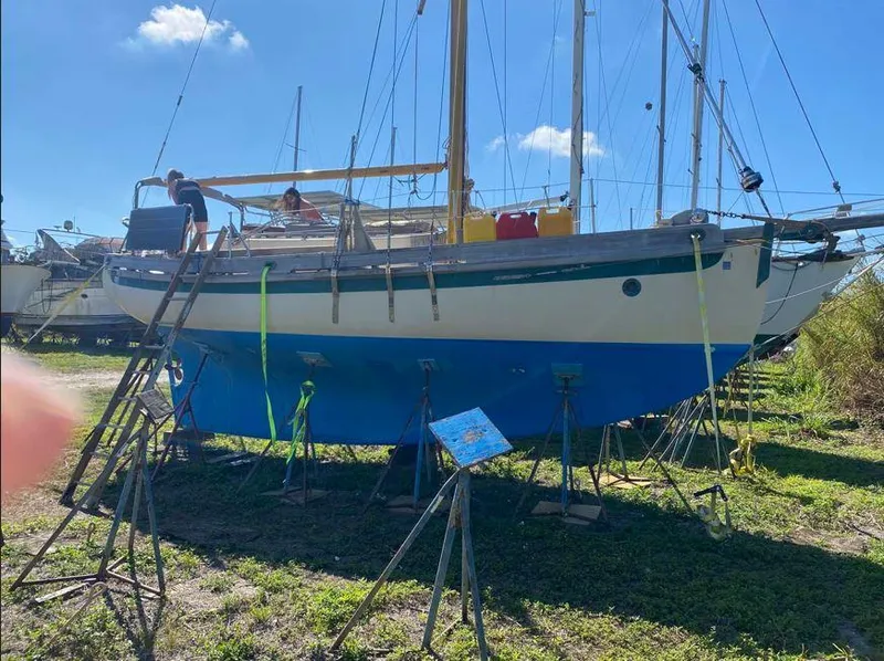 Slide: The Image of Bristol Channel Cutter 28 sailboat from 1990 on stands, undergoing maintenance. - 2