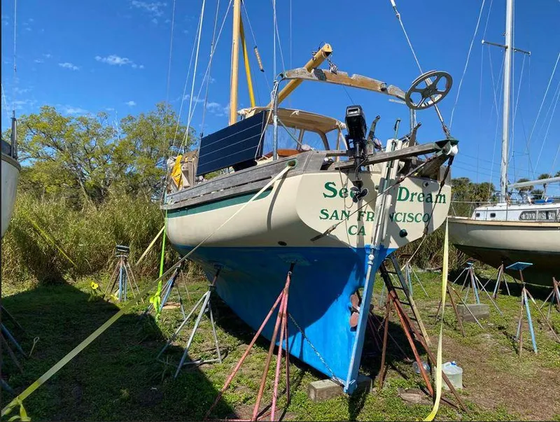 Slide: The Image of Bristol Channel Cutter 28 sailboat, 1990 model, on land with blue hull and solar panel. - 3