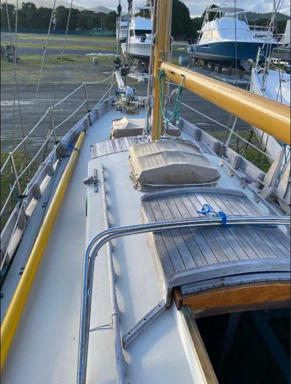 Slide: The Image of 1990 Bristol Channel Cutter 28 sailboat on land, showcasing deck and mast. - 6