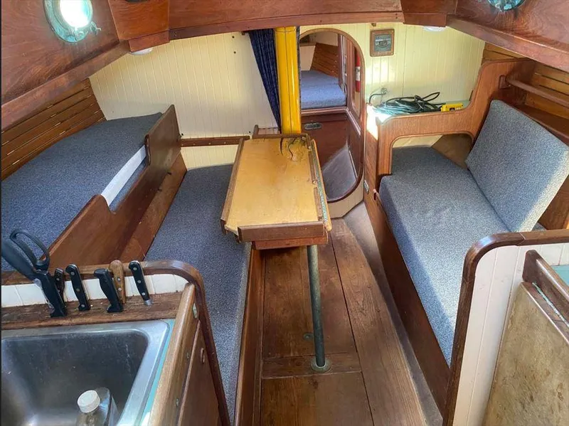 Slide: The Image of Interior of 1990 Bristol Channel Cutter 28 sailboat with cozy seating and wooden finishes. - 8