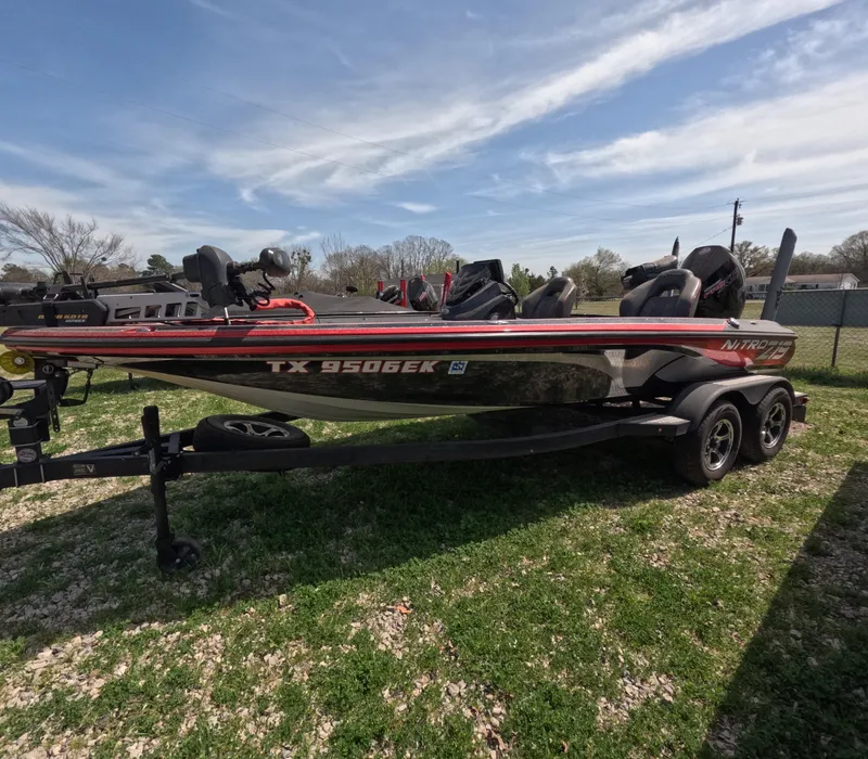 Slide: The Image of 2019 Nitro Z19 boat on trailer, parked on grass under a clear sky. - 0