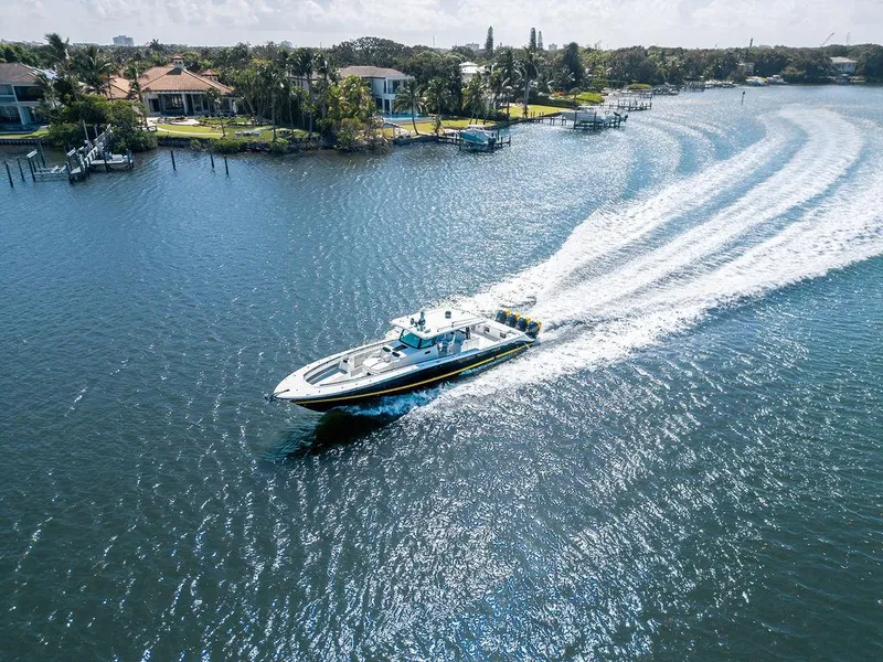 Slide: The Image of 2020 HCB 53 Sueños boat cruising on a scenic waterway near waterfront homes. - 42