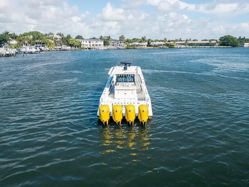 Slide: The Image of 2020 HCB 53 Sueños boat with four yellow engines on a calm waterway. - 48