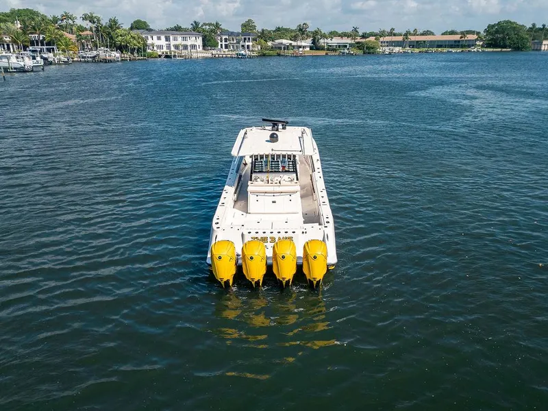 Slide: The Image of 2020 HCB 53 Sueños boat with four yellow engines on a calm lake. - 9
