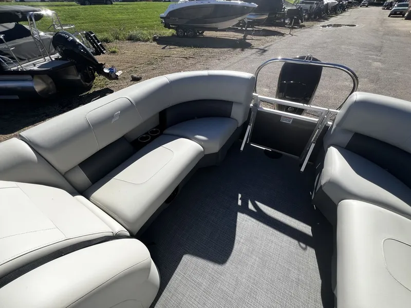 Slide: The Image of Starcraft LX 22 R 2025: Spacious pontoon boat interior with gray upholstered seating and cup holders. - 10