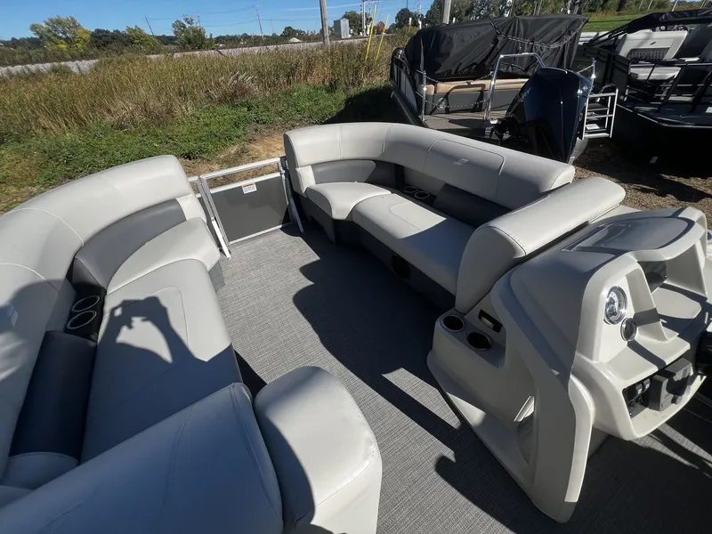 Slide: The Image of The image shows the interior of a Starcraft LX 22 R pontoon boat with gray seating and helm. - 4