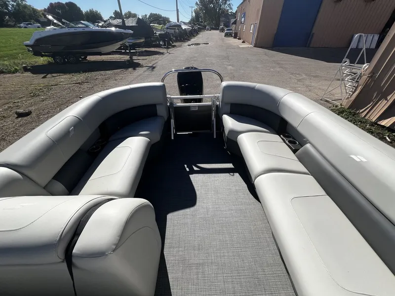 Slide: The Image of Starcraft LX 22 R 2025: Spacious pontoon boat with gray upholstery and open deck. - 8