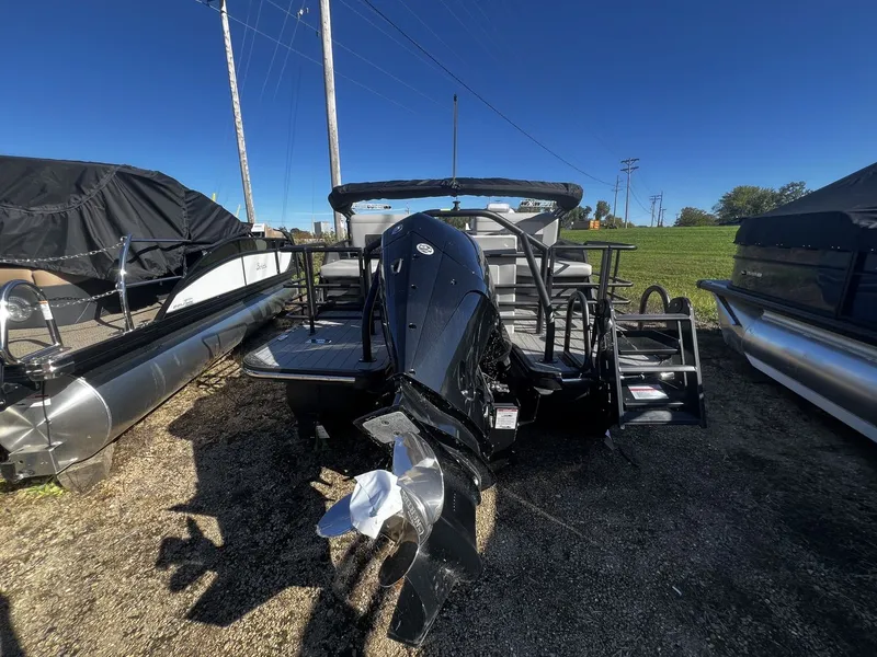 Slide: The Image of The image shows a 2025 Starcraft LX 22 R boat with an outboard motor, parked on a gravel lot. - 2
