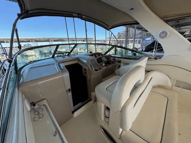 Slide: The Image of 2005 Sea Ray 360 Sundancer cockpit with helm, seating, and marina view. - 11