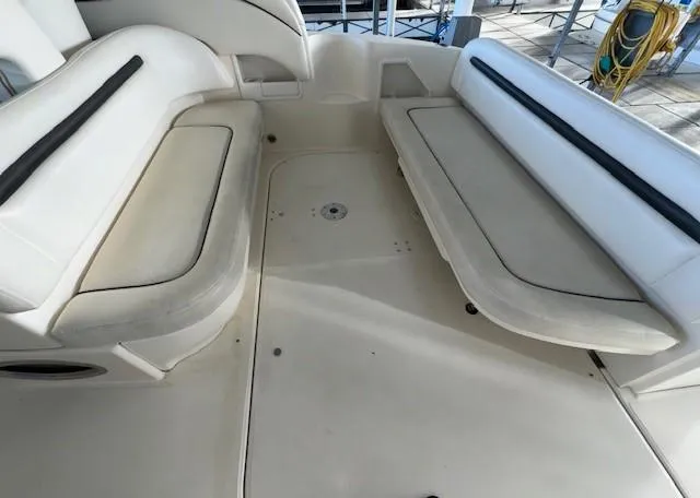 Slide: The Image of 2005 Sea Ray 360 Sundancer boat interior seating area with white cushions. - 12