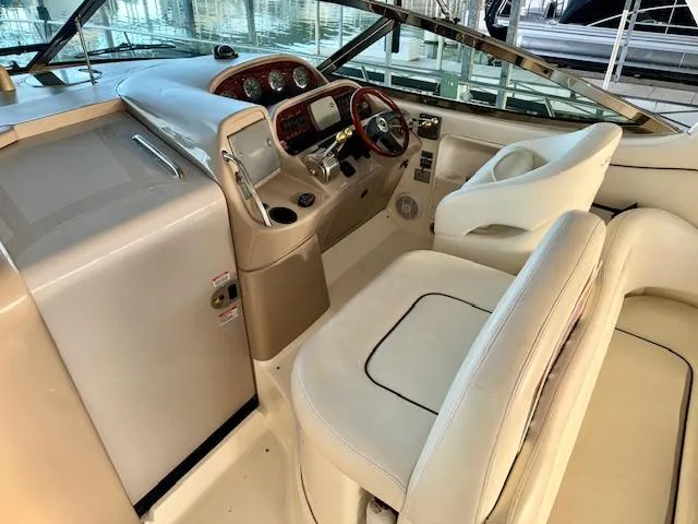 Slide: The Image of 2005 Sea Ray 360 Sundancer helm with beige seating and modern dashboard controls. - 14