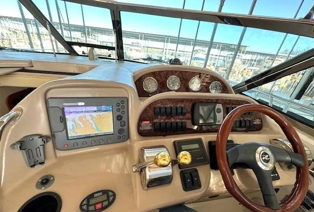 Slide: The Image of 2005 Sea Ray 360 Sundancer helm with GPS, gauges, and wood-accented steering wheel. - 19