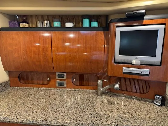 Slide: The Image of 2005 Sea Ray 360 Sundancer interior with wood cabinets, granite countertop, and built-in TV. - 30
