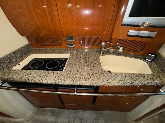 Slide: The Image of 2005 Sea Ray 360 Sundancer kitchen with granite countertop, stove, and sink. - 31