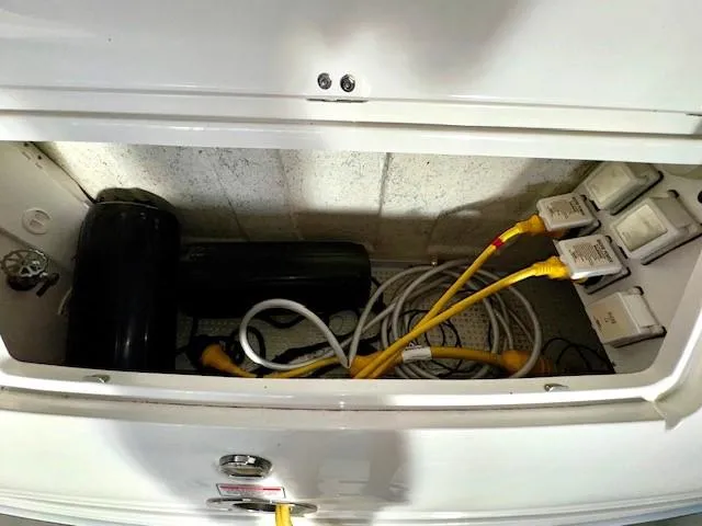 Slide: The Image of Storage compartment of 2005 Sea Ray 360 Sundancer with cables and equipment. - 6