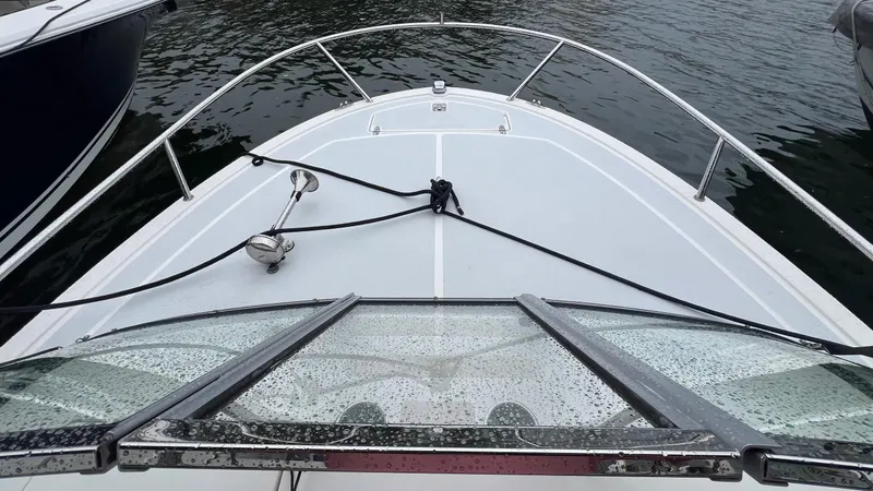 Slide: The Image of Bow view of 2013 Vanquish 24 Runabout boat on water, featuring sleek design and railing. - 6