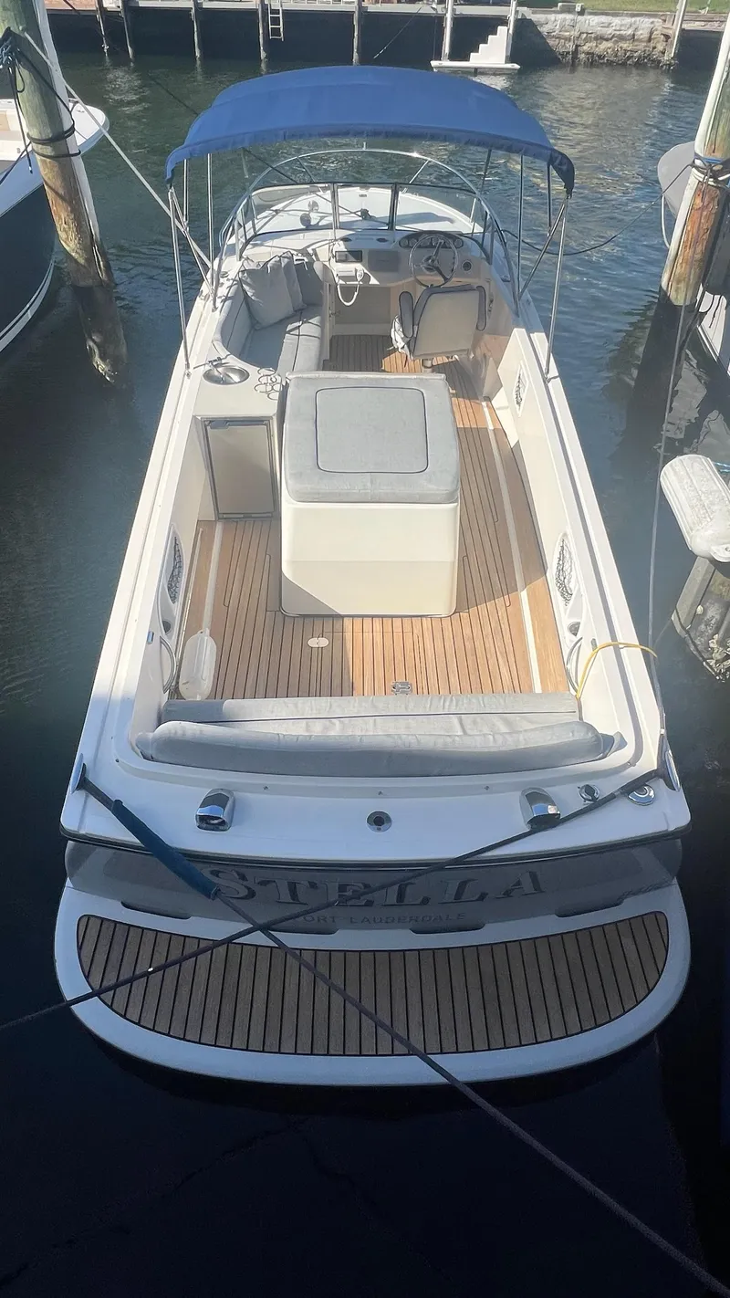 Slide: The Image of 2013 Vanquish 24 Runabout boat with blue canopy, docked in marina. - 7