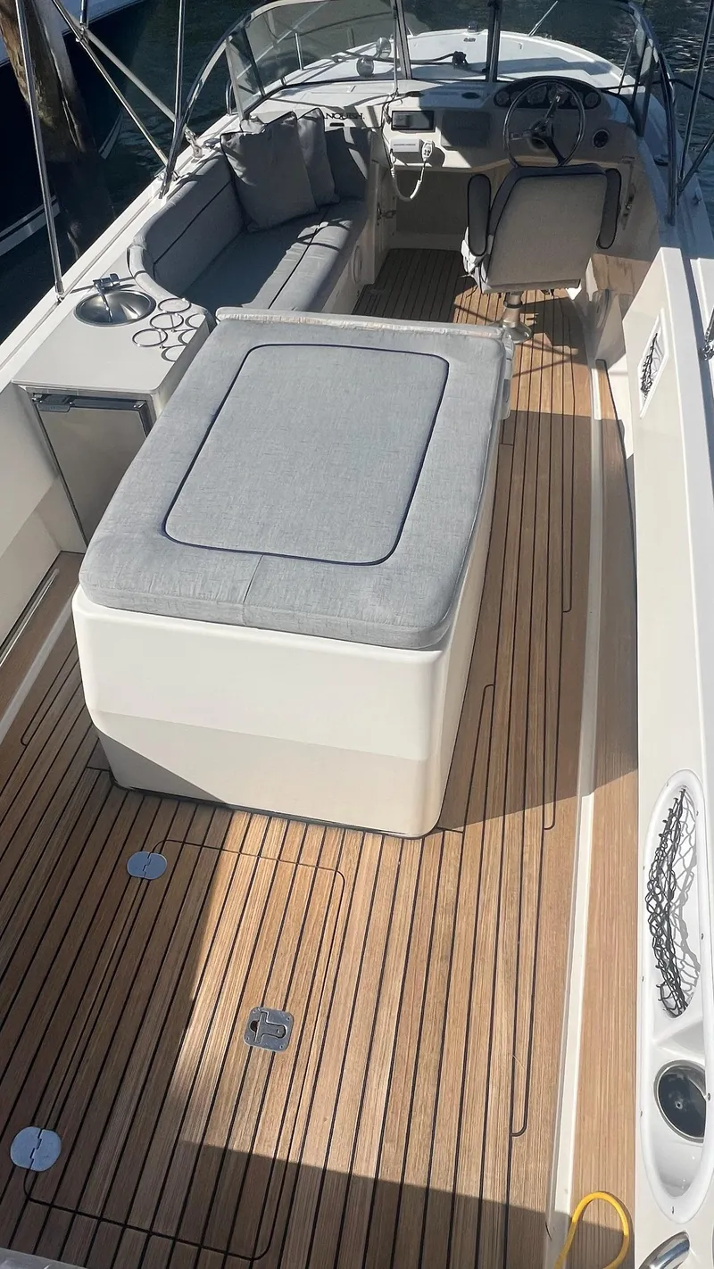 Slide: The Image of 2013 Vanquish 24 Runabout boat with teak deck and cushioned seating. - 8