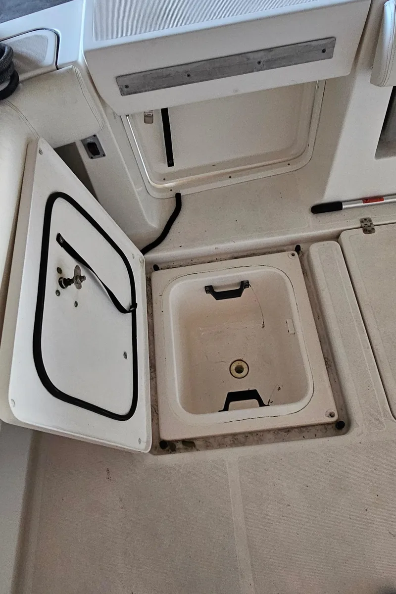 Slide: The Image of 2002 Pursuit 3800 Express boat storage compartments with open hatches. - 11