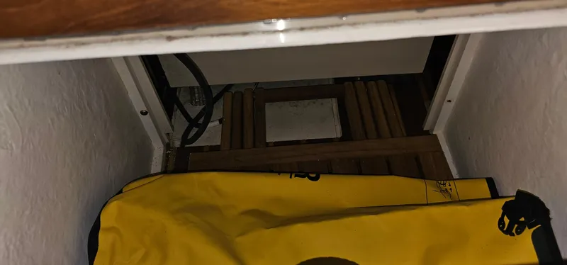 Slide: The Image of Storage compartment in a 2002 Pursuit 3800 Express boat with yellow bag and wooden slats. - 26
