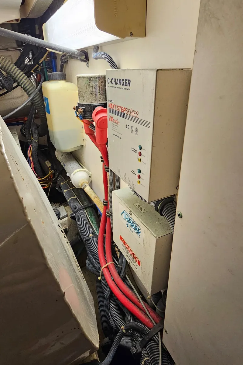 Slide: The Image of Engine room of a 2002 Pursuit 3800 Express with battery chargers and wiring. - 34