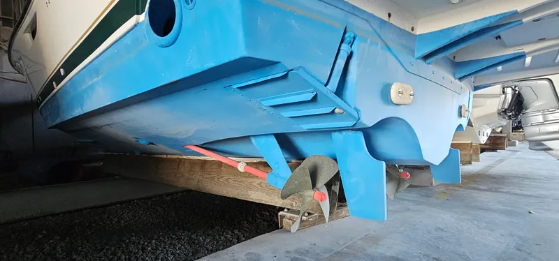 Slide: The Image of 2002 Pursuit 3800 Express boat hull in dry dock, showcasing blue underside and propeller. - 39
