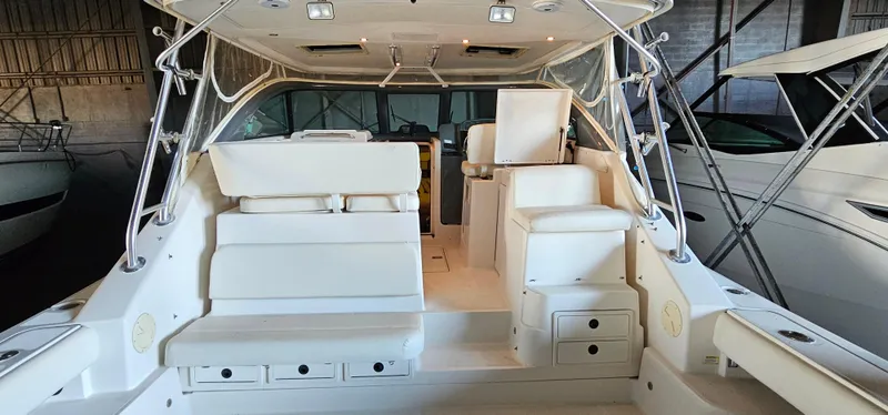 Slide: The Image of 2002 Pursuit 3800 Express boat interior with white seating and storage compartments. - 4