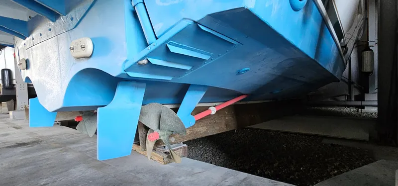 Slide: The Image of 2002 Pursuit 3800 Express boat hull in dry dock, supported by wooden blocks. - 40