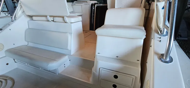 Slide: The Image of 2002 Pursuit 3800 Express boat interior with white seating and storage compartments. - 5