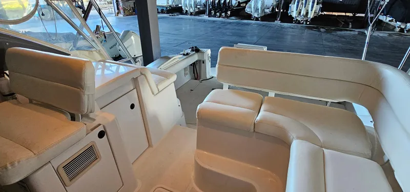 Slide: The Image of 2002 Pursuit 3800 Express boat interior with white seating and storage compartments. - 8