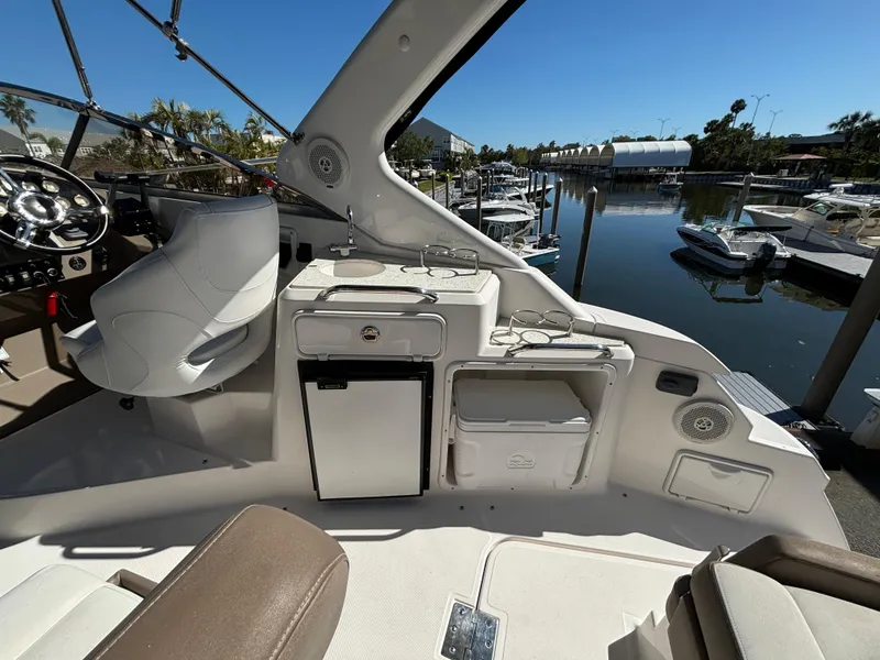 Slide: The Image of 2016 Regal 30 Express boat interior with helm, seating, and marina view. - 5