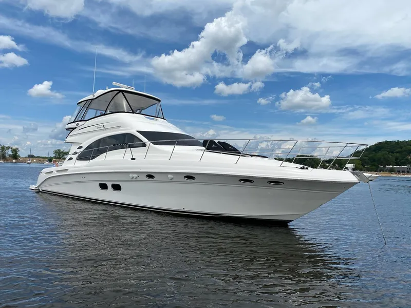 Slide: The Image of 2009 Sea Ray 580 Sedan Bridge yacht on calm water under a blue sky. - 24