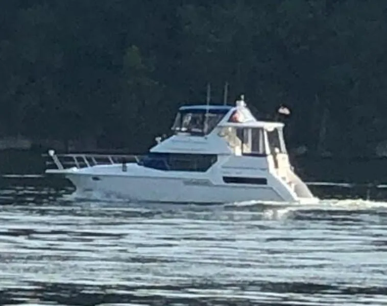 Slide: The Image of 1996 Carver 355 Aft Cabin cruising on a calm lake. - 0