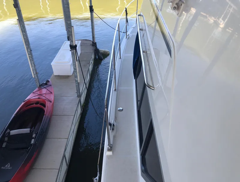 Slide: The Image of 1996 Carver 355 Aft Cabin yacht docked beside a red kayak. - 10