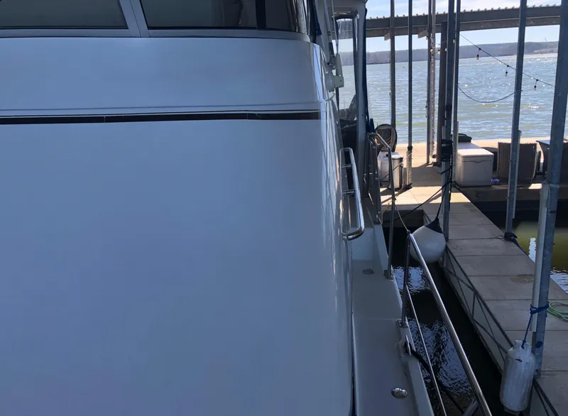 Slide: The Image of 1996 Carver 355 Aft Cabin yacht docked at a marina with water view. - 11
