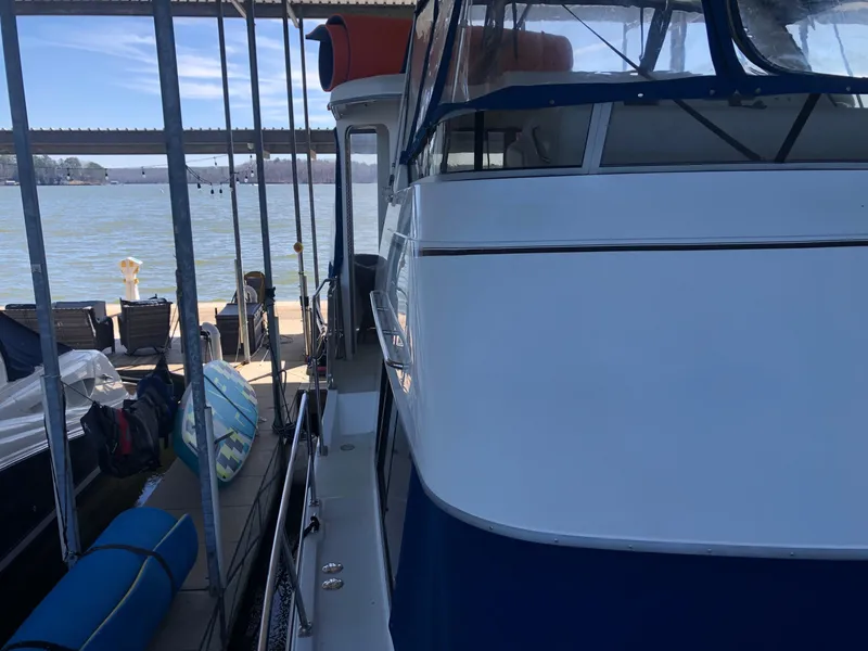 Slide: The Image of 1996 Carver 355 Aft Cabin yacht docked, side view with water in background. - 12