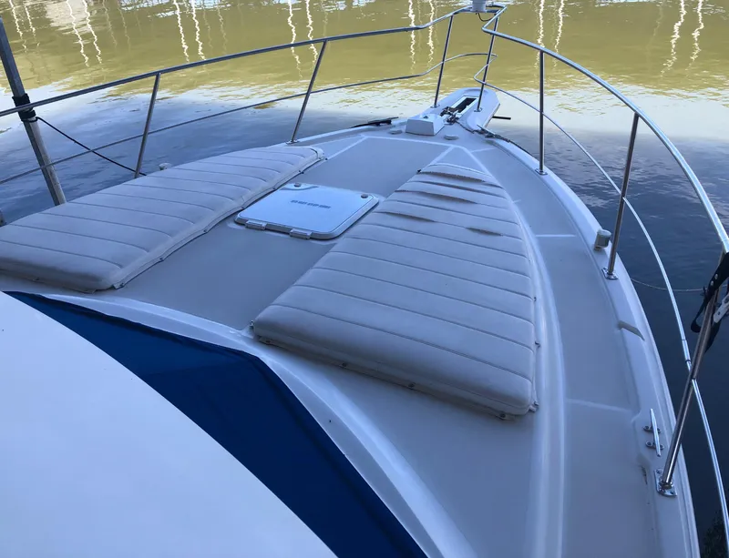 Slide: The Image of 1996 Carver 355 Aft Cabin boat deck with cushioned seating and railing. - 15