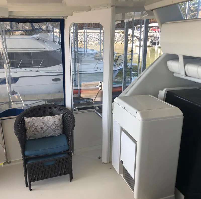 Slide: The Image of 1996 Carver 355 Aft Cabin interior with wicker chair and marina view. - 17