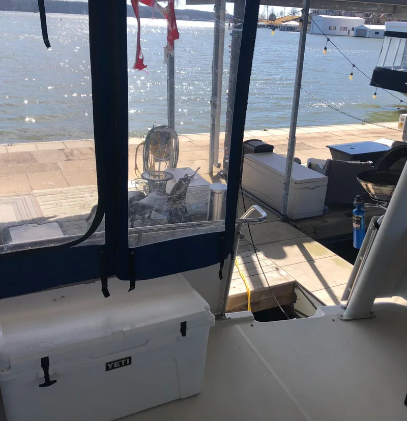 Slide: The Image of 1996 Carver 355 Aft Cabin yacht docked by the water with a Yeti cooler. - 19