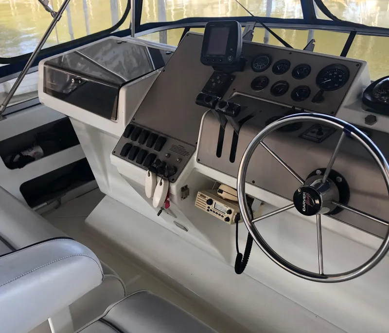 Slide: The Image of 1996 Carver 355 Aft Cabin helm with steering wheel, gauges, and navigation equipment. - 21