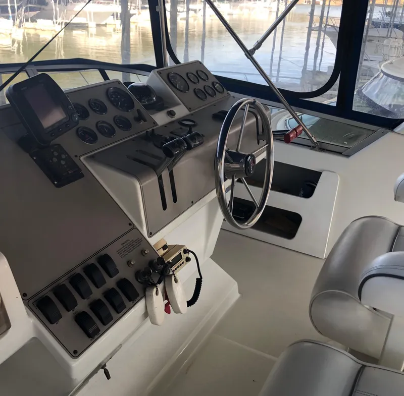 Slide: The Image of 1996 Carver 355 Aft Cabin helm with steering wheel and control panel. - 22