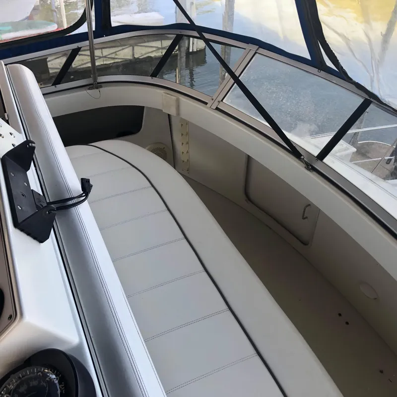 Slide: The Image of 1996 Carver 355 Aft Cabin interior with white seating and navigation equipment. - 26