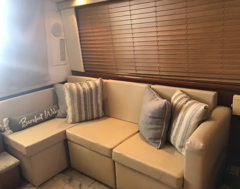 Slide: The Image of 1996 Carver 355 Aft Cabin interior with beige sofa, decorative pillows, and wooden blinds. - 36