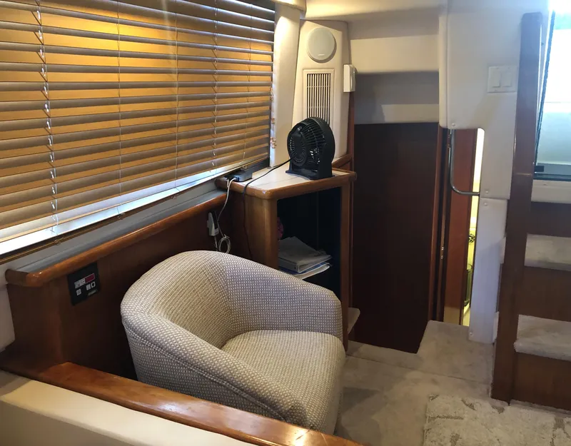 Slide: The Image of 1996 Carver 355 Aft Cabin interior with cozy chair and wooden accents. - 37
