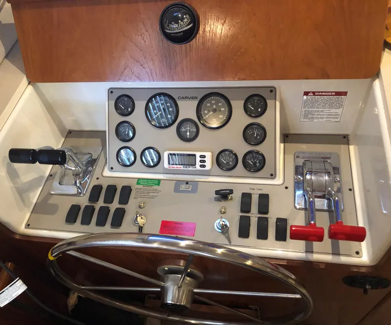 Slide: The Image of 1996 Carver 355 Aft Cabin helm with gauges, controls, and steering wheel. - 38