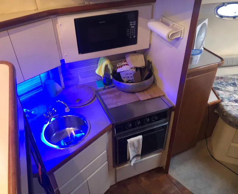 Slide: The Image of 1996 Carver 355 Aft Cabin kitchen with sink, stove, and microwave. - 42